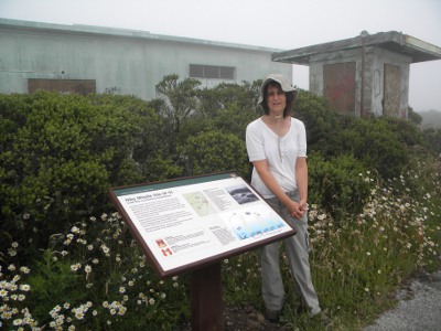 Brenda stands next to the sign at the IFC.  The IFC is now part of Sweeney Ridge in the Golden Gate National Recreation Area.