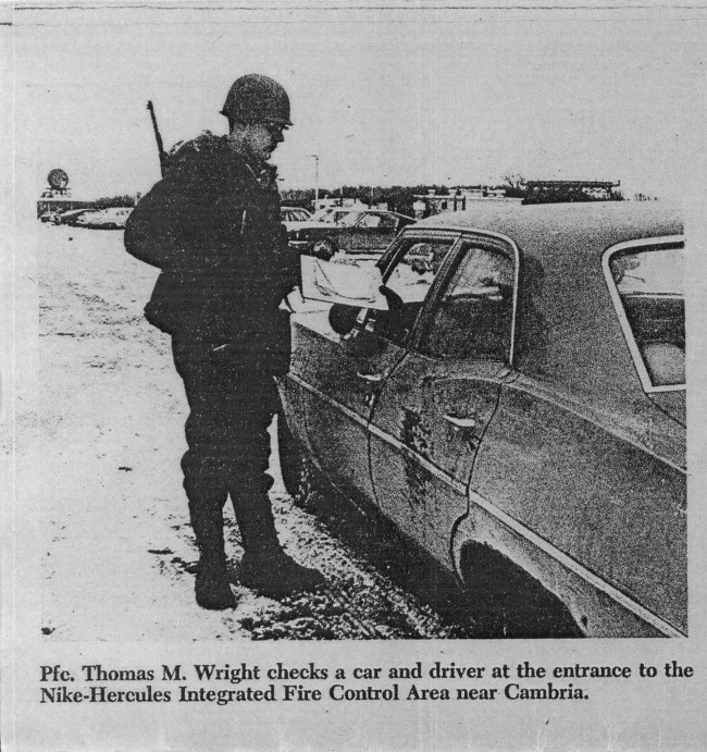 P.F.C. Thimas M. Wright checks a car and driver at the entrance to the Nike-Hercules Integrated Fire Control Area near Cambria.