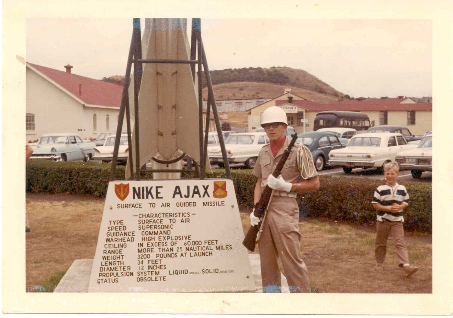 In Aug,'66 Terry Fetterman, dressed in color guard uniform, stands beside a monument to the obsolete Nike Ajax missile at Fort Baker, California.